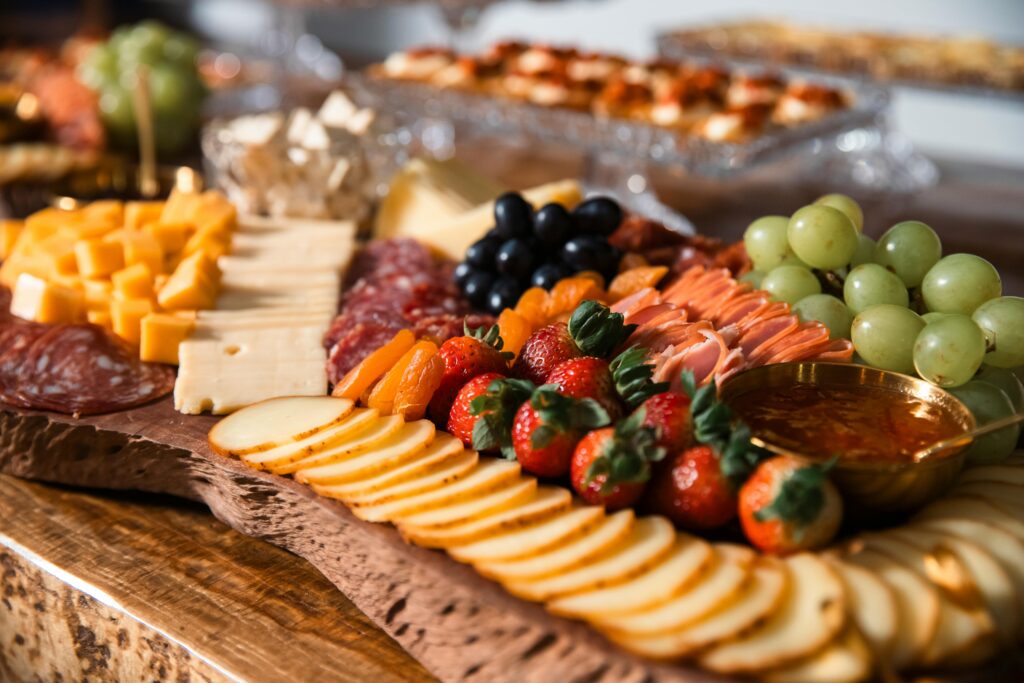 Elegant cheese and charcuterie board with fresh fruits and gourmet selection.
