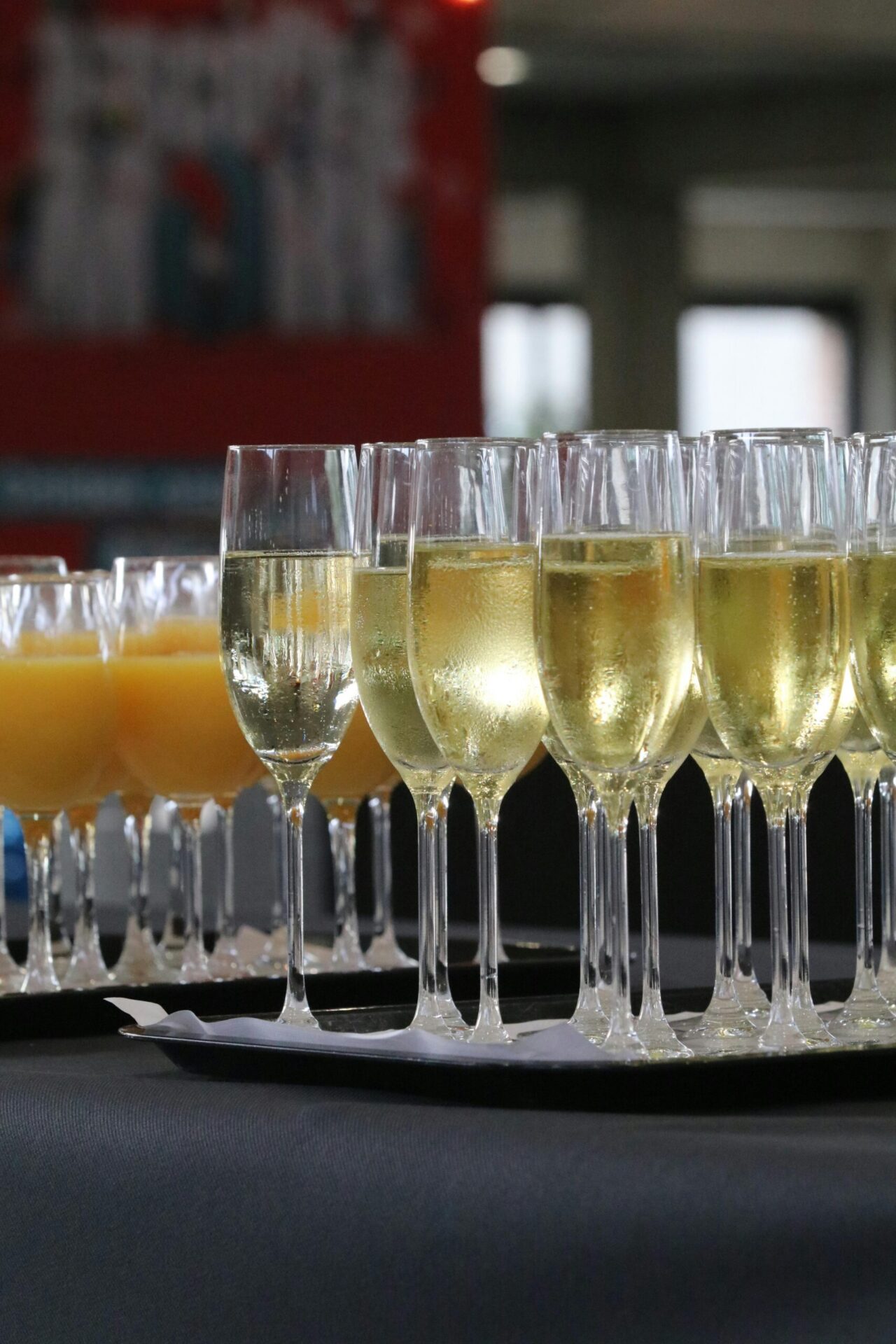 Elegant array of champagne and orange juice glasses at an indoor event, ready for celebration.