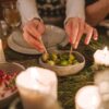 A warm holiday dinner setting featuring brussels sprouts, salad, and candlelight, perfect for seasonal gatherings.